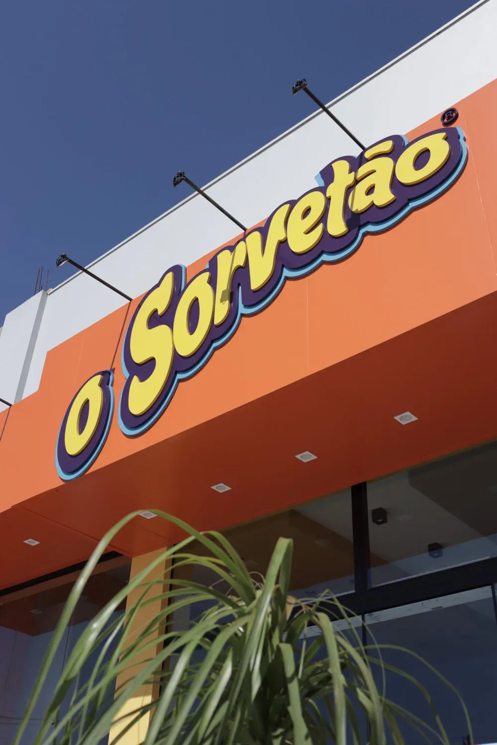 Fachada com letreiro iluminado da sorveteria O Sorvetão, por D'Caris