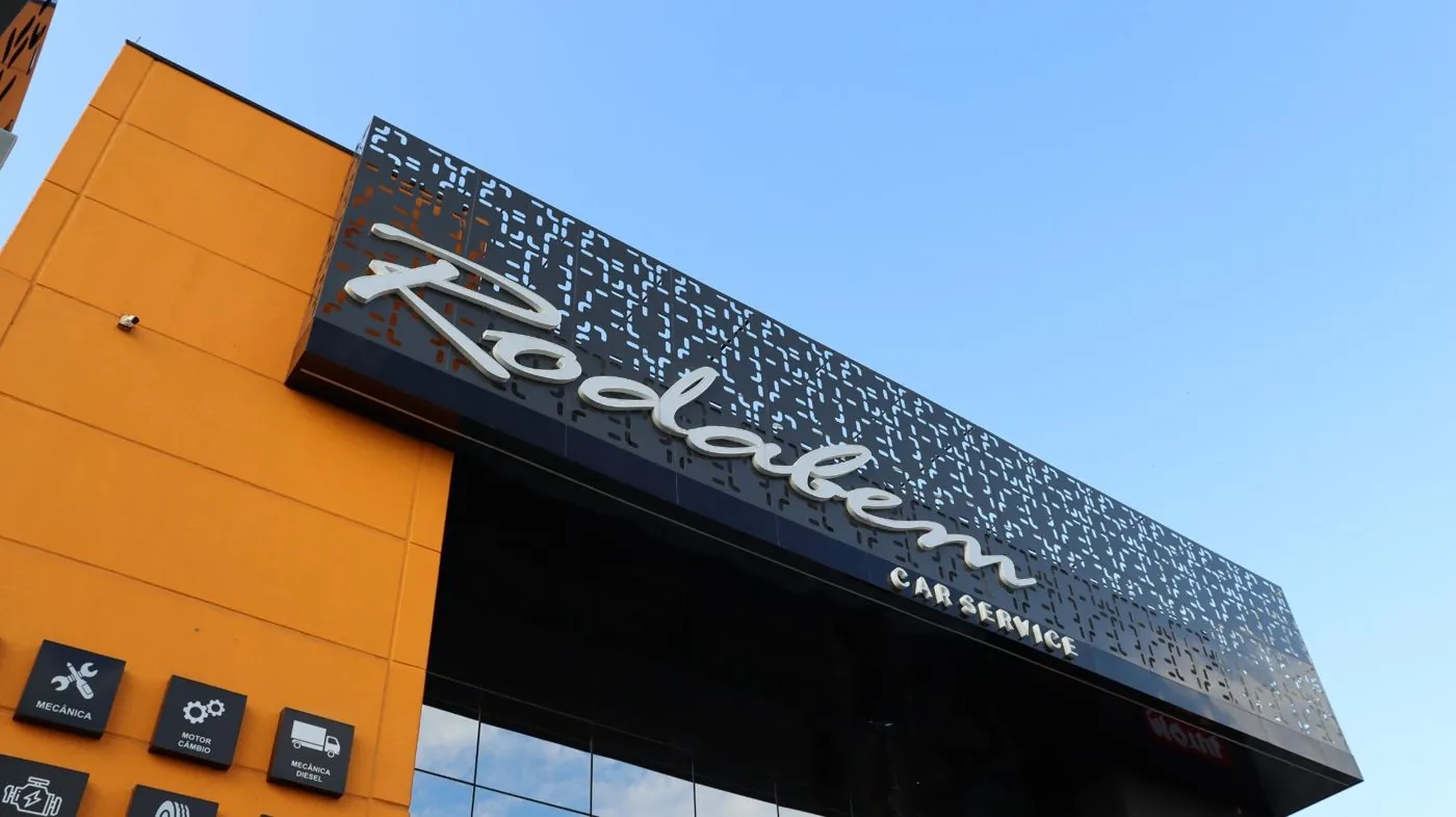 Letra caixa em script sobre ACM perfurado da Rodabem Car Service, por D'Caris